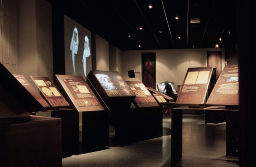 Photo of Mazamet Cathar museum room. Dark room displaying a few booths and photos.